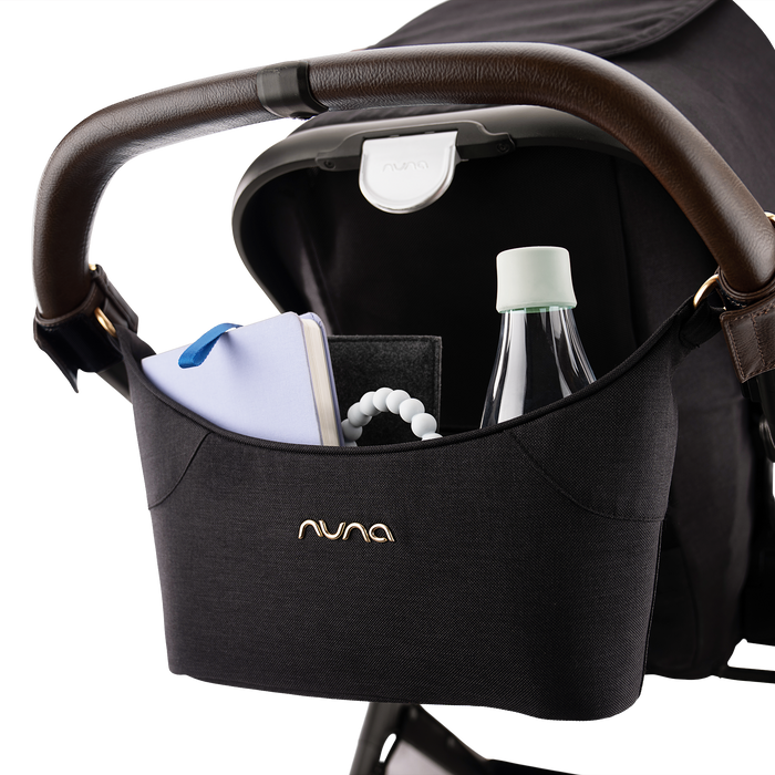 [Caviar/Chocolate] Black Nuna handlebar organizer pouch containing a water bottle, book, and teether.