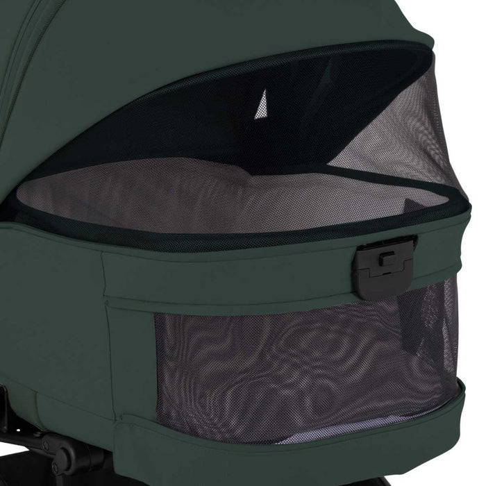 Close-up of open mesh ventilation panels on a dark green stroller bassinet.