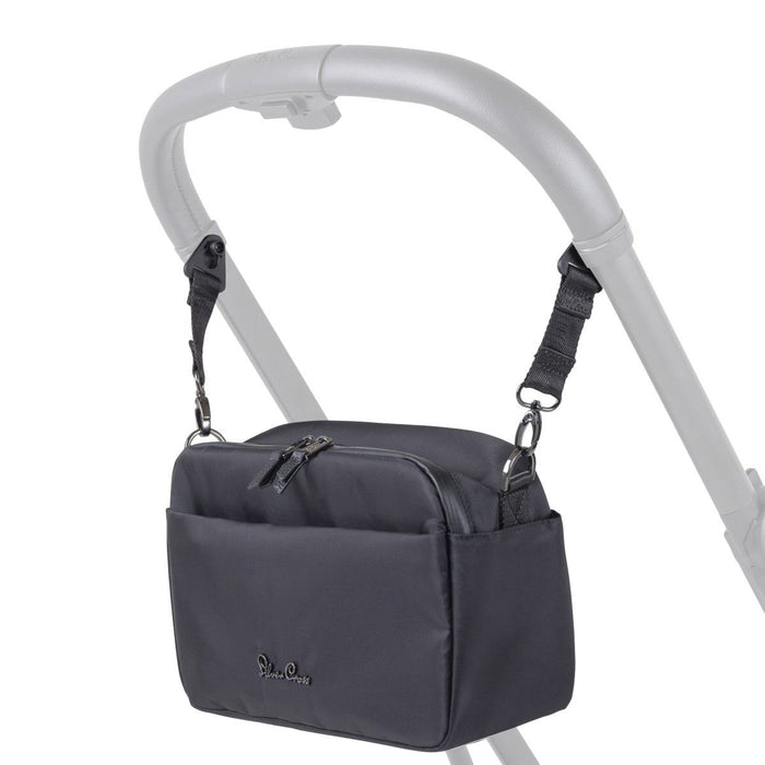 A black fabric stroller organizer bag hanging from a silver stroller handlebar by adjustable straps.
