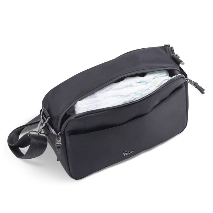 An open black diaper bag organizer packed with folded white diapers inside.